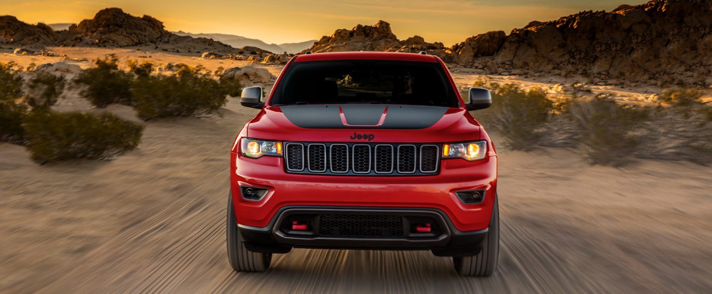 The 2021 Jeep Grand Cherokee Trailhawk being driven on sandy terrain.