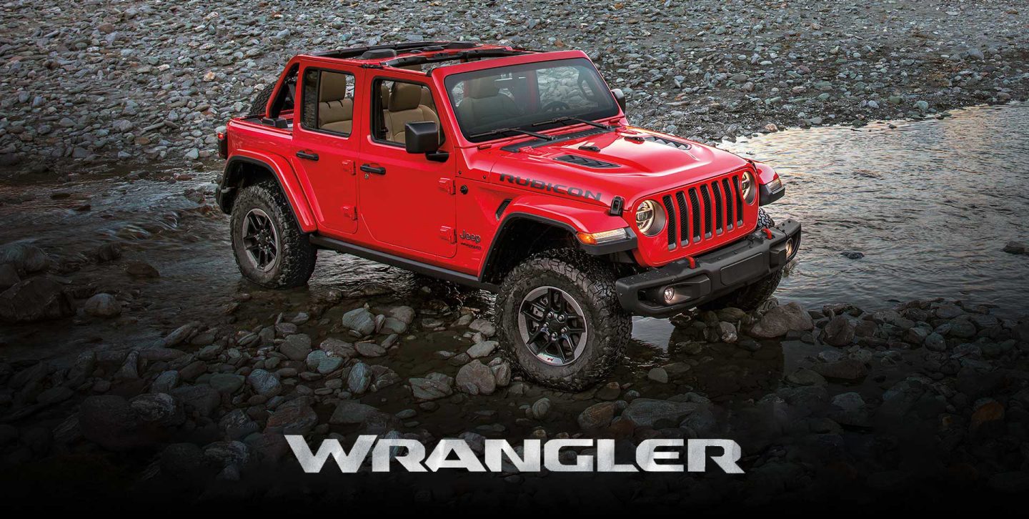 The 2022 Jeep Wrangler Unlimited Rubicon parked in the path of a shallow, rocky stream. The Jeep Celebration Event logo.